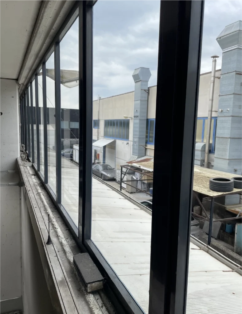 finestra industriale con vetri rotti da sostituire in un'azienda di Padova